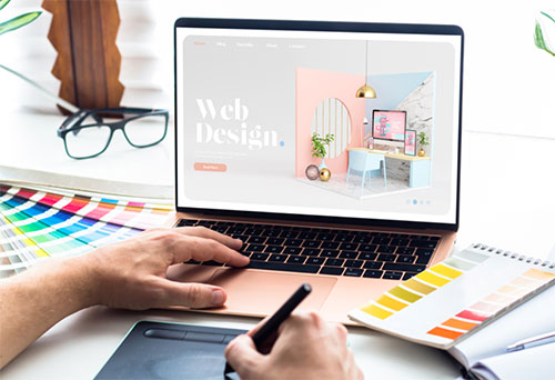 An image showing a graphic designer working on web design using their laptop, for the blog post by Fullframe Creative.