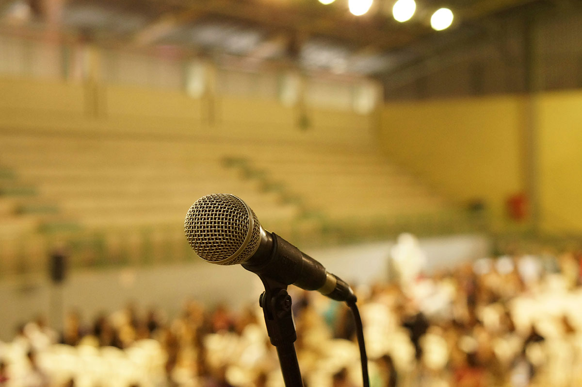 An image of a microphone and a blurry crowd for the fullframe blog post on interview video production, image by joao cruz on unsplash