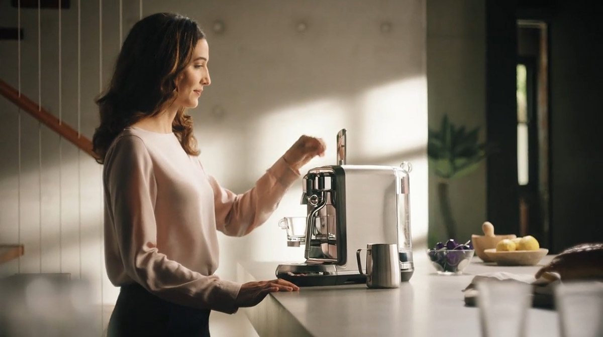 A corporate branding advert photograph showing a woman pouring herself from Nespresso coffee, taken by Fullframe Creative, in which their office is based in Bussigny, near Lausanne.
