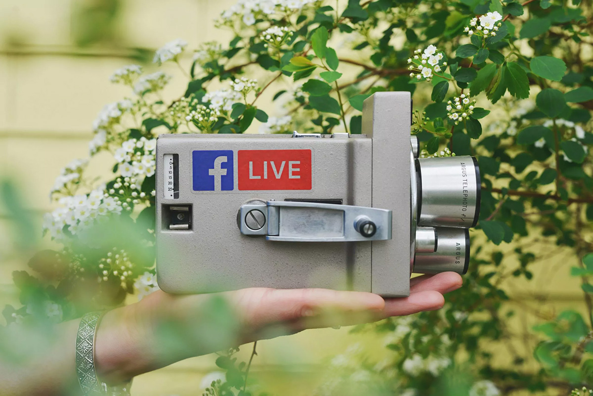 Image of someone holding a video camera with a facebook live sticker on it for live video production image par sticker mule sur unsplash