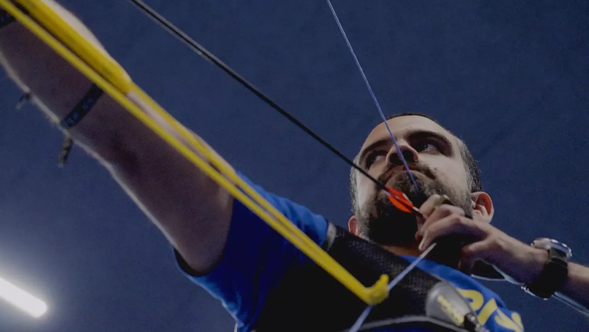 Athlete shooting an arrow with a bow in documentary by world archery and fullframe creative